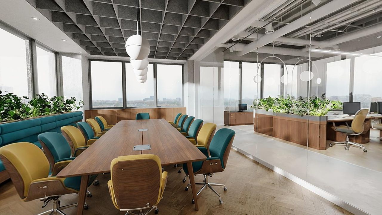 Salle de réunion vitrée d’un plateau de bureaux, longue table en bois et fauteuils jaunes et bleu canard, vue de la visite 360